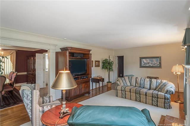 living area with ornate columns, ornamental molding, and wood finished floors