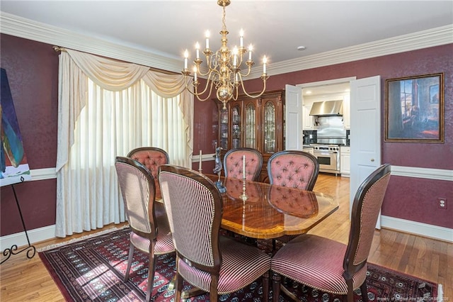 dining space featuring ornamental molding, a notable chandelier, light wood-style flooring, and baseboards