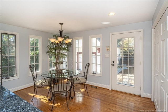 dining room featuring a healthy amount of sunlight, visible vents, and wood finished floors