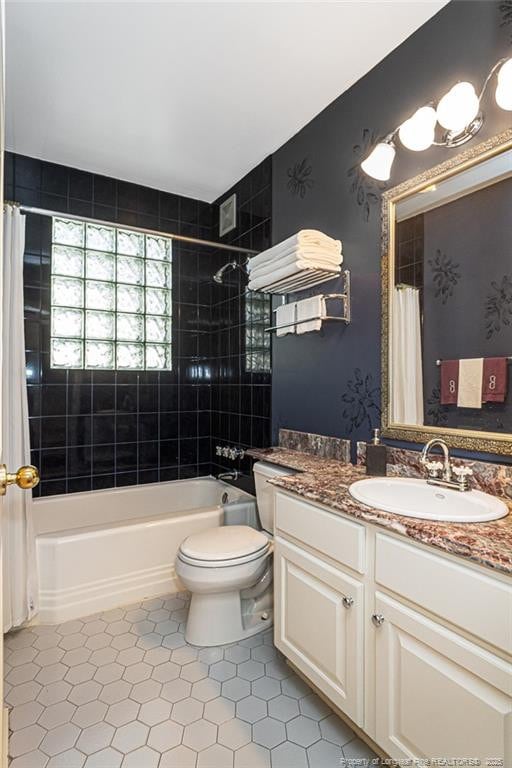 bathroom with shower / bath combo, vanity, and toilet