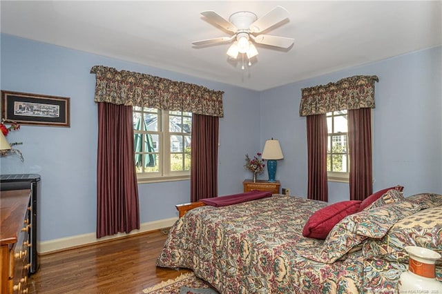 bedroom featuring a ceiling fan, baseboards, and wood finished floors