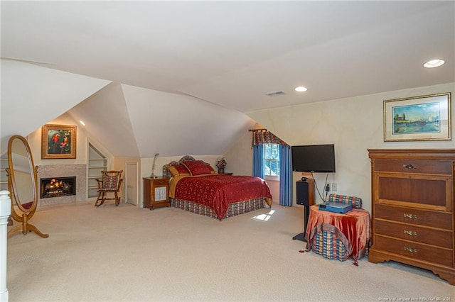 bedroom featuring lofted ceiling, recessed lighting, a fireplace, visible vents, and carpet