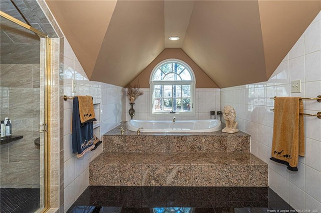 full bath with a stall shower, vaulted ceiling, tile walls, and a bath