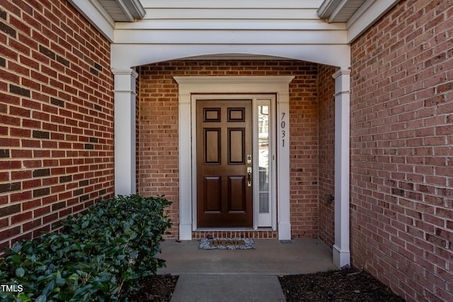 doorway to property featuring brick siding