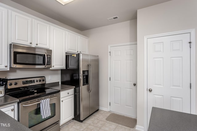 kitchen with dark countertops, visible vents, appliances with stainless steel finishes, and white cabinetry