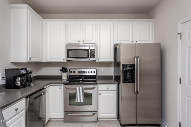 kitchen with dark countertops, white cabinets, and stainless steel appliances