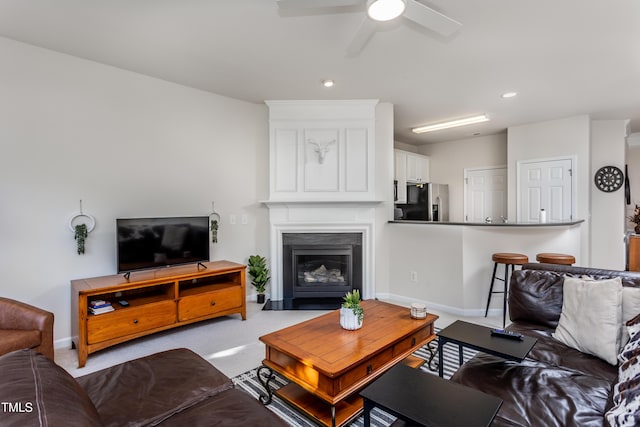 carpeted living room with recessed lighting, a fireplace, baseboards, and a ceiling fan