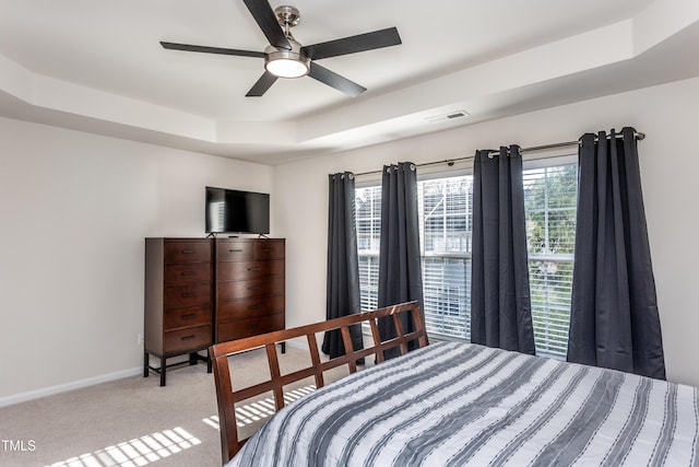 bedroom with visible vents, baseboards, carpet, a raised ceiling, and ceiling fan