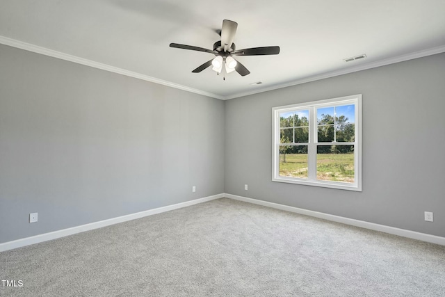 carpeted empty room featuring visible vents, crown molding, baseboards, and ceiling fan