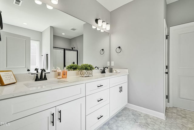 bathroom with double vanity, visible vents, and a sink