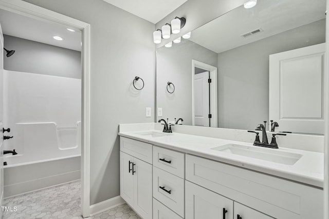 bathroom with double vanity, a sink, visible vents, and baseboards