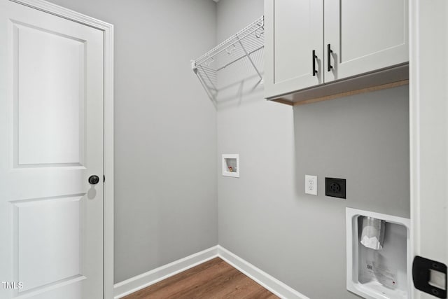 washroom with dark wood finished floors, hookup for a washing machine, cabinet space, hookup for an electric dryer, and baseboards