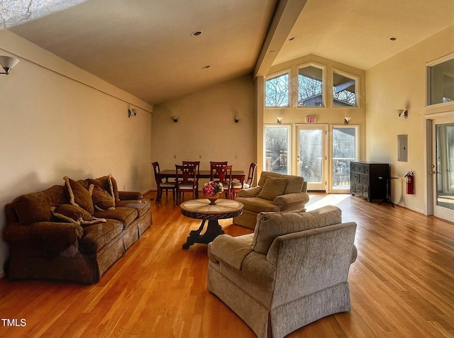 living room with electric panel, beamed ceiling, high vaulted ceiling, and wood finished floors