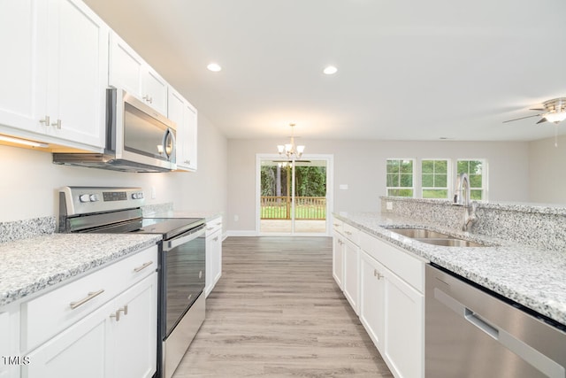 kitchen featuring stainless steel appliances, light wood-style floors, white cabinetry, a sink, and recessed lighting