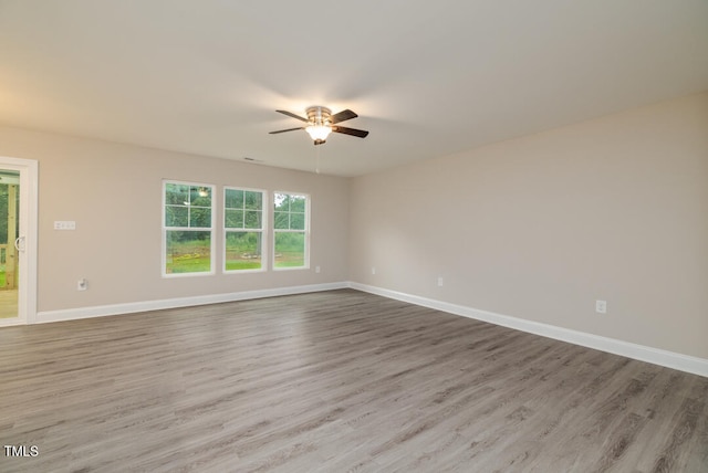 spare room with ceiling fan, baseboards, and wood finished floors