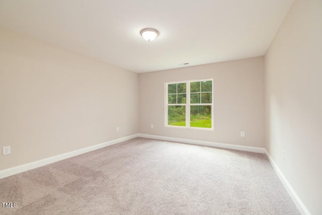 unfurnished room with carpet flooring, visible vents, and baseboards