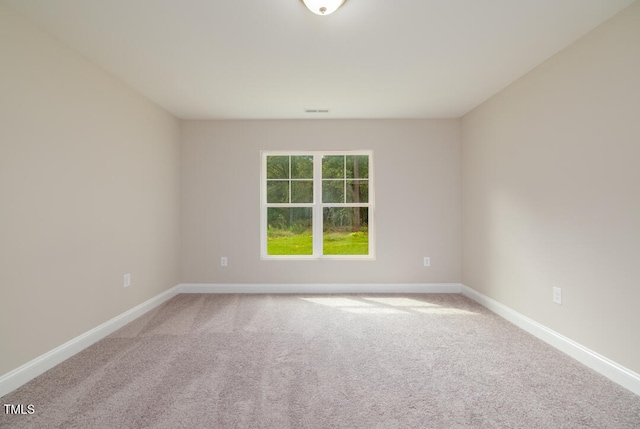 carpeted empty room featuring visible vents and baseboards