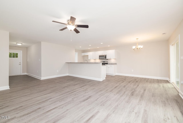 unfurnished living room with light wood-type flooring, recessed lighting, baseboards, and ceiling fan with notable chandelier