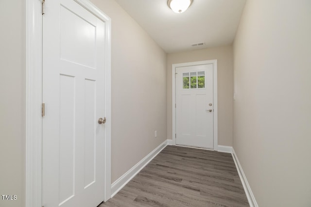 doorway to outside featuring wood finished floors, visible vents, and baseboards