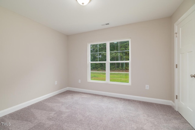 empty room featuring carpet floors, visible vents, and baseboards