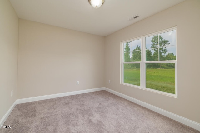 unfurnished room featuring visible vents, light colored carpet, and baseboards