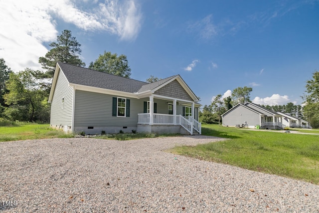 view of front of property featuring a porch, a shingled roof, a front yard, crawl space, and driveway