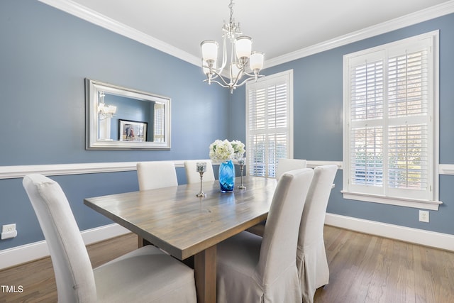 dining space featuring ornamental molding, a wealth of natural light, baseboards, and wood finished floors