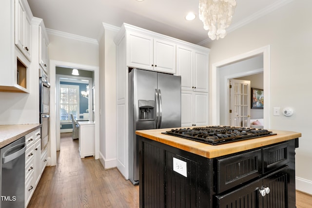 kitchen with white cabinets, wooden counters, appliances with stainless steel finishes, dark cabinetry, and crown molding