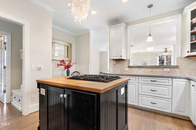 kitchen with black gas cooktop, butcher block countertops, ornamental molding, and white cabinetry