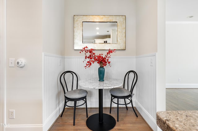 dining area featuring a wainscoted wall and wood finished floors