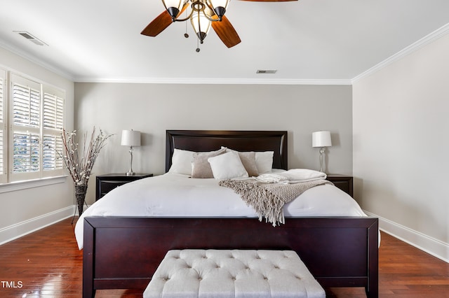 bedroom featuring crown molding, visible vents, and wood finished floors