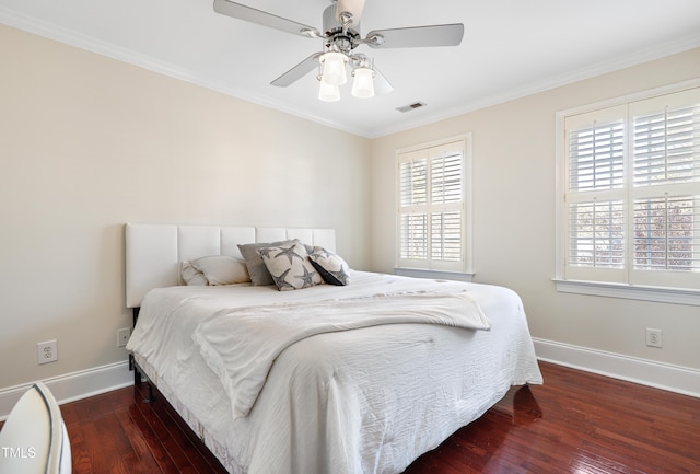 bedroom featuring ceiling fan, visible vents, baseboards, hardwood / wood-style floors, and crown molding