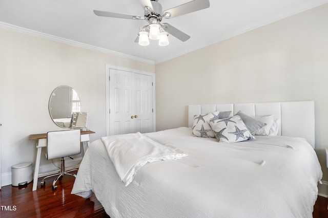 bedroom featuring a closet, crown molding, baseboards, and wood finished floors