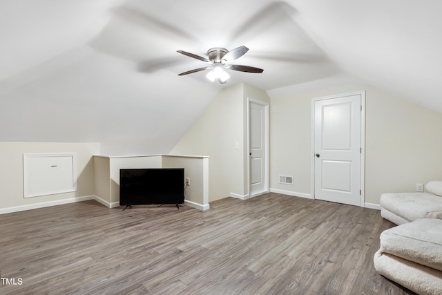 bonus room featuring baseboards, visible vents, ceiling fan, wood finished floors, and vaulted ceiling