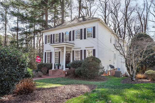 colonial home featuring a front yard and central AC