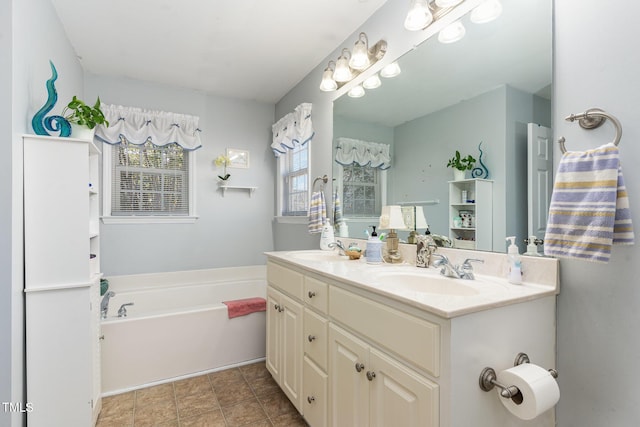 bathroom with double vanity, a garden tub, and a sink