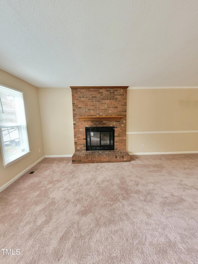 unfurnished living room with visible vents, baseboards, a textured ceiling, carpet flooring, and a fireplace