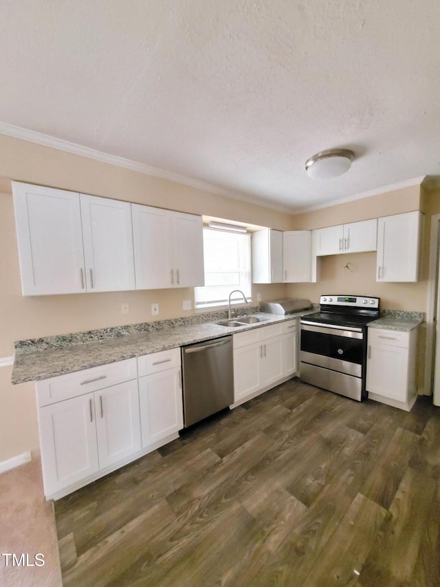 kitchen featuring stainless steel appliances, a sink, white cabinetry, and crown molding