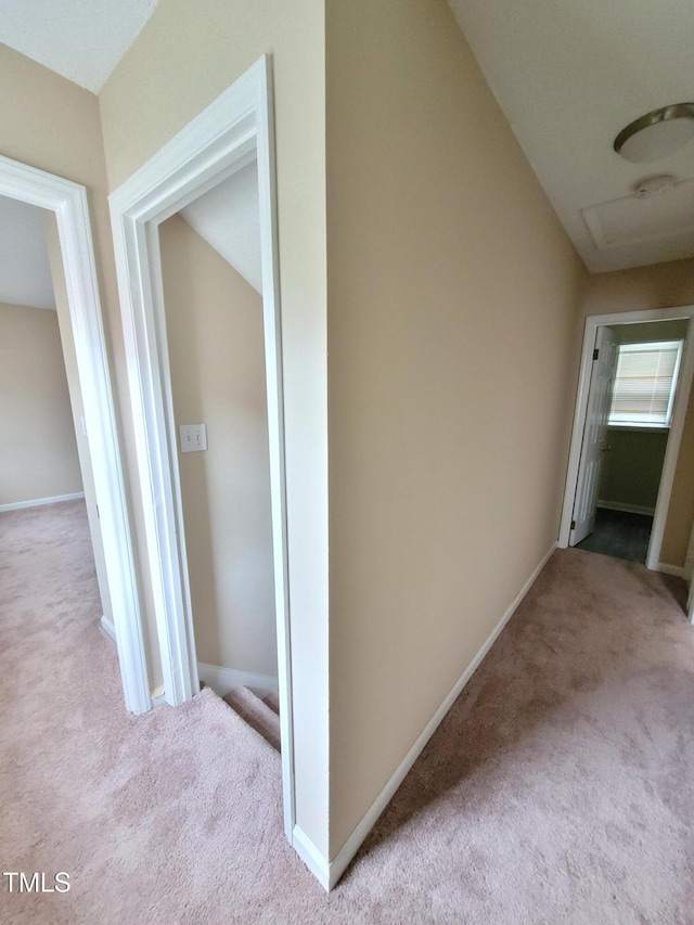 corridor featuring lofted ceiling, baseboards, and carpet flooring