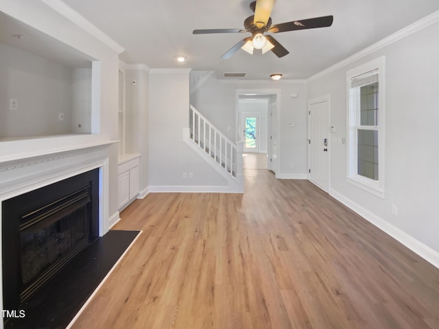 unfurnished living room featuring visible vents, baseboards, stairway, ornamental molding, and a fireplace