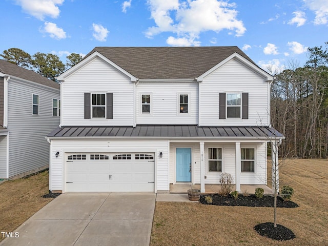 view of front of property featuring metal roof, covered porch, a garage, driveway, and a standing seam roof