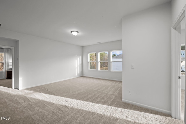 spare room featuring carpet and baseboards