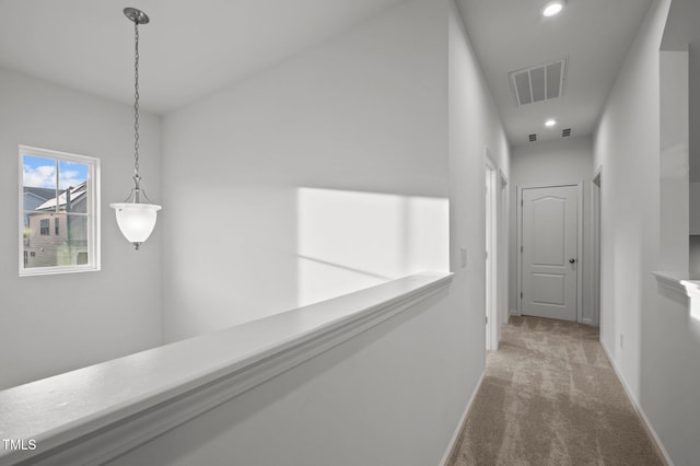 hall with carpet floors, recessed lighting, visible vents, and baseboards