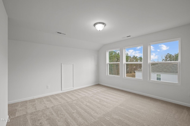 interior space with vaulted ceiling, carpet flooring, visible vents, and baseboards