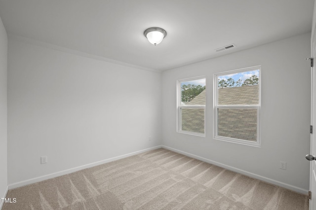 spare room featuring baseboards, visible vents, and light colored carpet