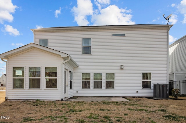 rear view of property featuring central air condition unit, fence, a lawn, and a patio