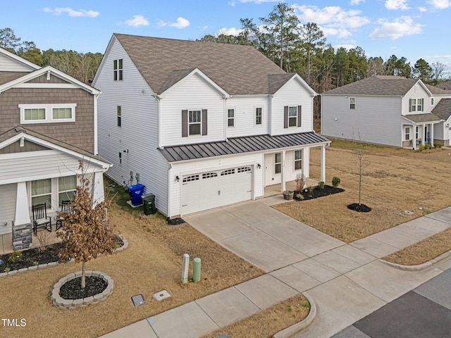 view of front of home with metal roof, a porch, concrete driveway, roof with shingles, and a standing seam roof