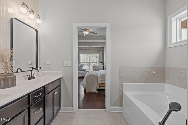 ensuite bathroom featuring double vanity, ensuite bathroom, a sink, tile patterned flooring, and a bath