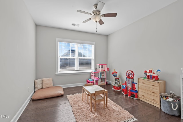 rec room with dark wood-style floors, a ceiling fan, visible vents, and baseboards