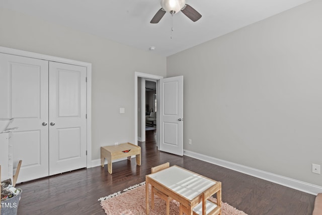 living area with dark wood-style floors, ceiling fan, and baseboards